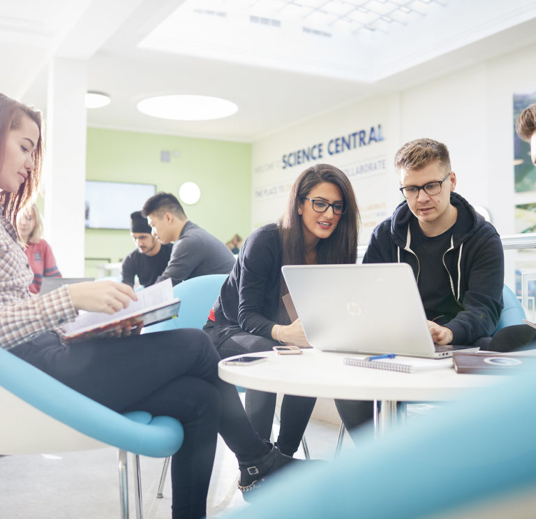 Students looking at laptop and notes 