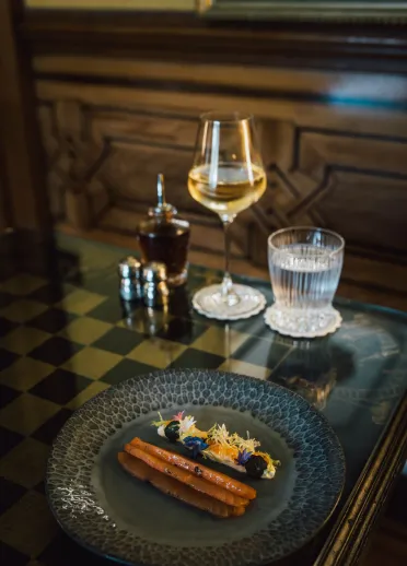 A plate of food and a glass of wine and water