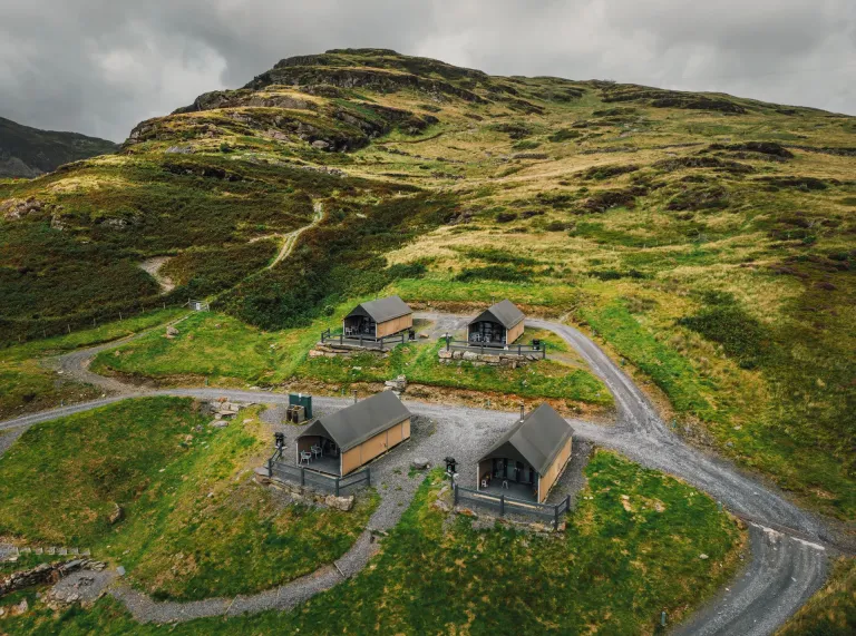 a view of the glamping pods surrounded by mountains