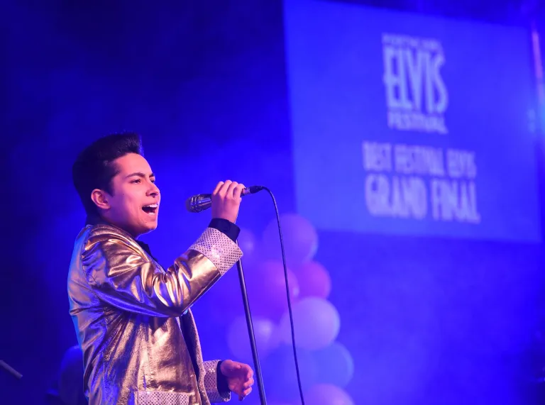 An Elvis tribute act singing into a microphone
