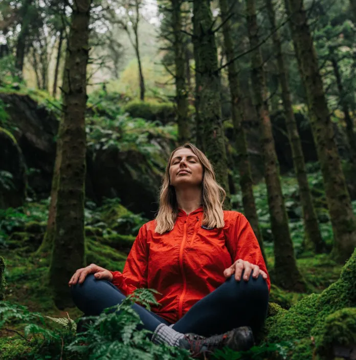 A woman sitting in the forest.