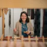 Welsh textile artist Llio James sitting at her hand weaving loom, smiling at the camera