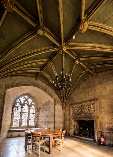 A table and chairs on a stone floor next to a fireplace.