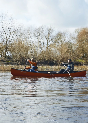 Two people in a boat on a river.