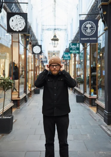Huw Stephens holding beanie hat in Cardiff's Victorian Arcades