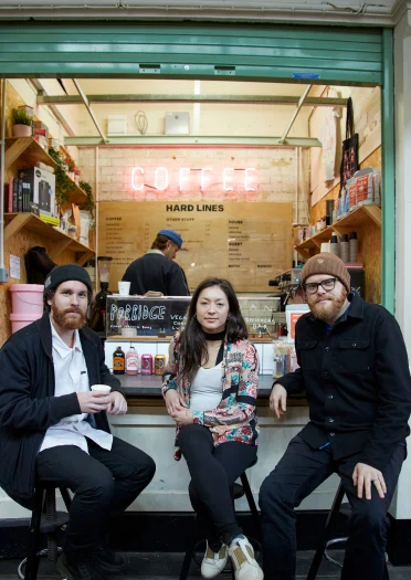 Huw Stephens sat with friends outside Hard Lines Coffee