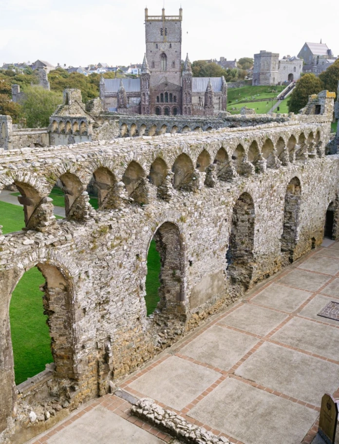 A series of old castle ruins with a large cathedral in the background
