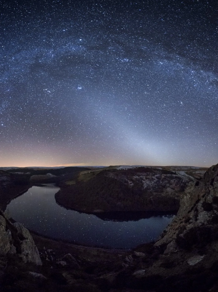 Night shot of a valley with lake and starry skies