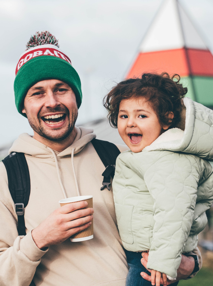 A man holding a small child, both smiling.