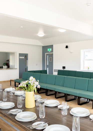 A long table laid out with dinner plates.