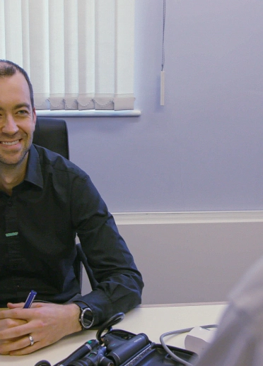 GP Calum Forrester-Paton at his desk in the surgery with a patient