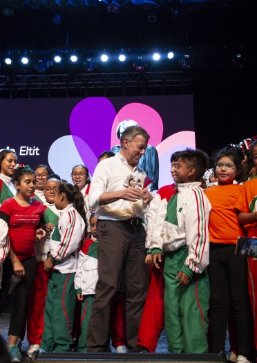A group of children and a man on stage.