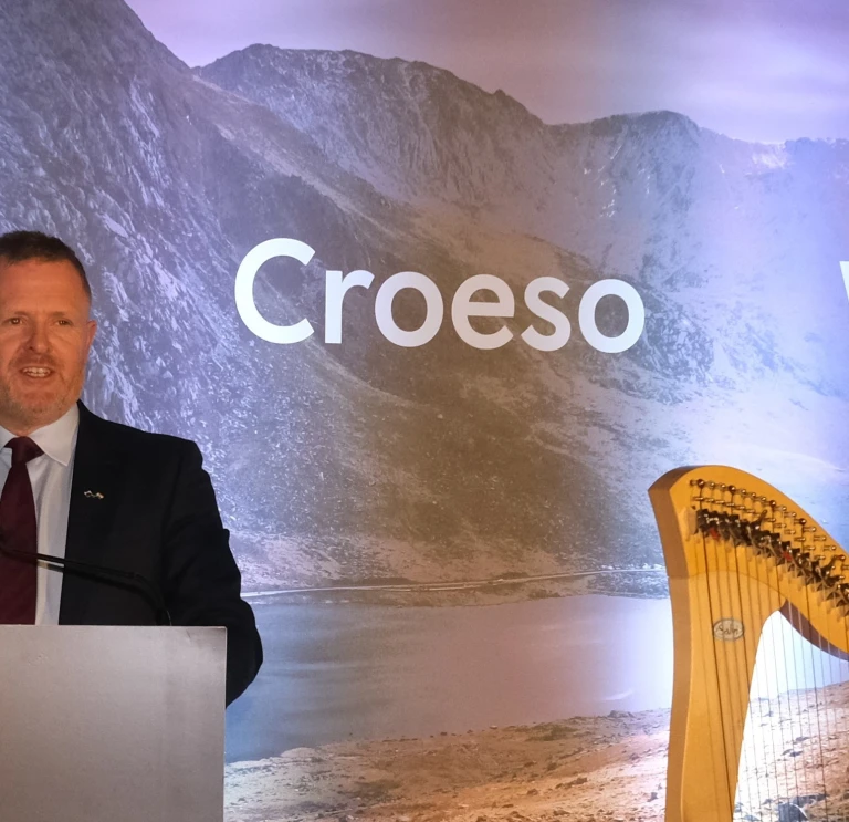 Health Secretary stood in front of welcome boards 