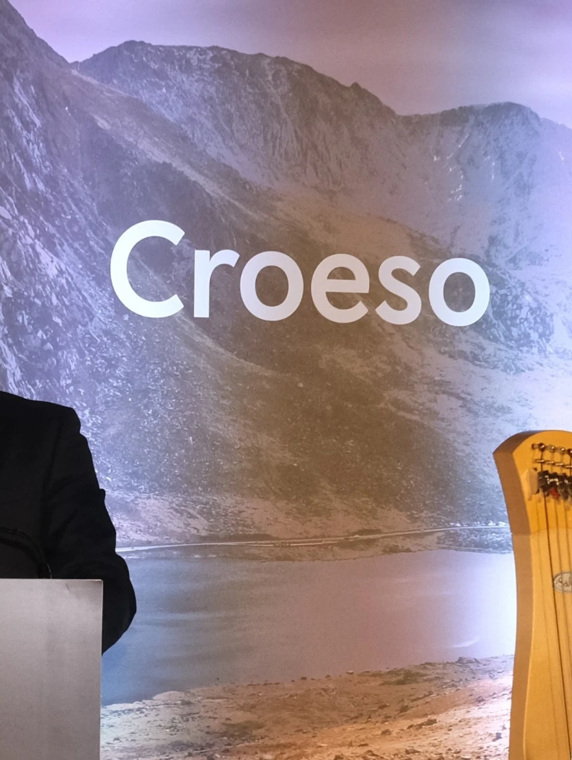 Health Secretary stood in front of welcome boards 