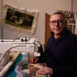 Man sat at table making art