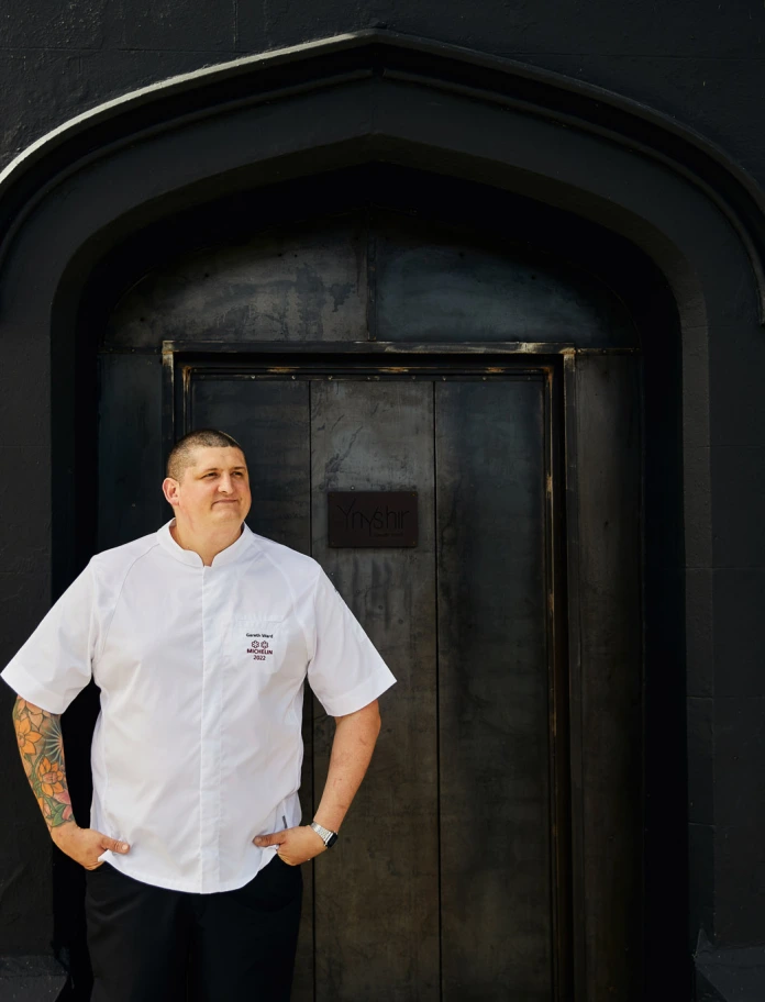 Gareth Ward standing in front of a door.