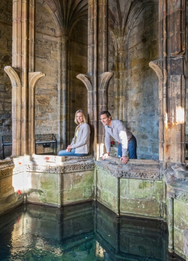 Two people looking into the well.