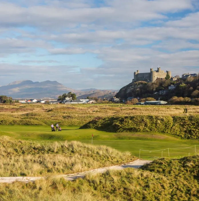 A scenic golf course with a large castle on a hill in the background