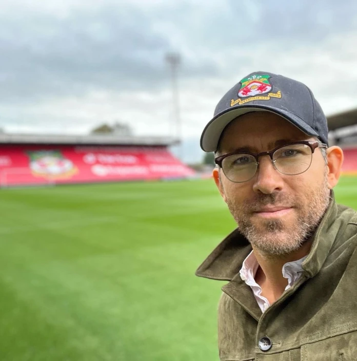 A man standing on a football pitch looking into the camera