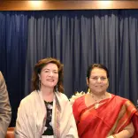 Two women in between two men smiling for camera