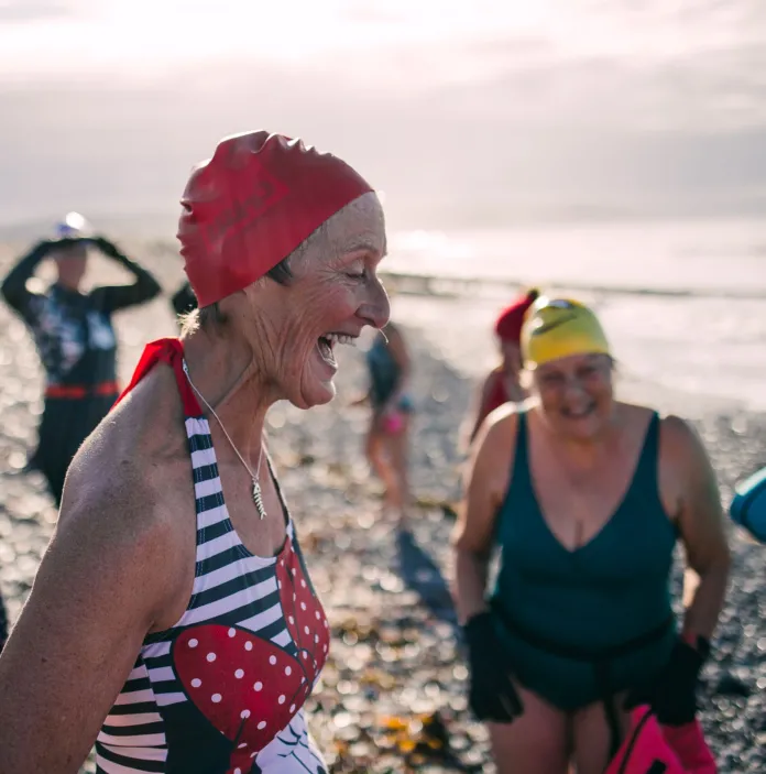 A group of women in swimming costumes on a beach