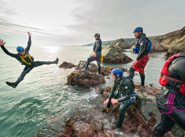 Group of men Coasteering near St Davids, Pembrokeshire