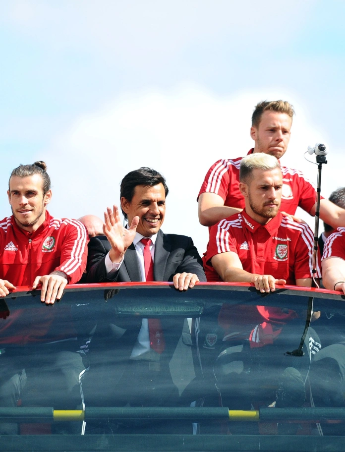 Football players waving from their tour bus.
