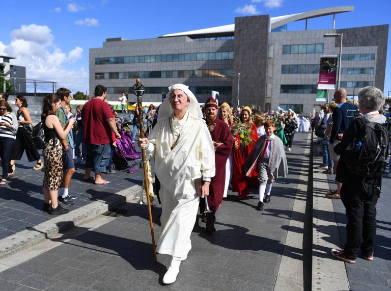 People walking through a crowd in costume.