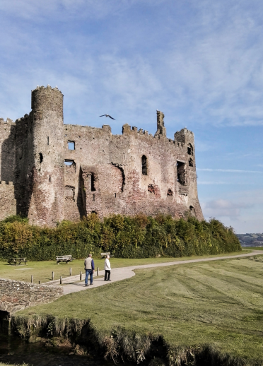 people walking near Laugharne Castle