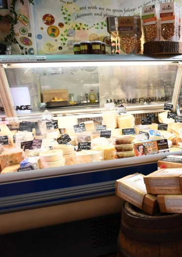 Interior shot of a cheese store with cheese behind the counter