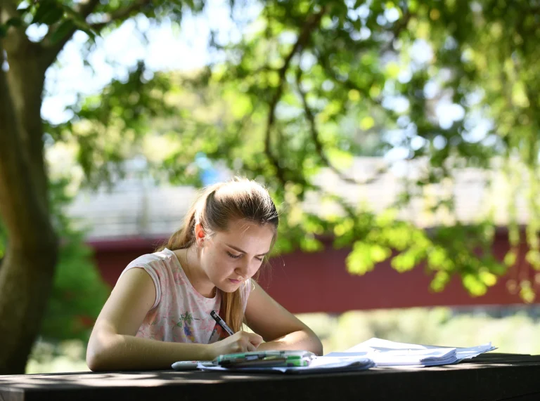 Girl studying on a bench in Bute Park, Cardiff