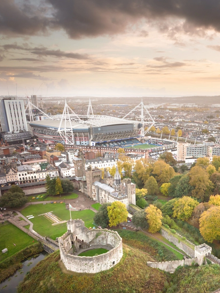 Aerial view over a city with large castle, park and stadium in view 
