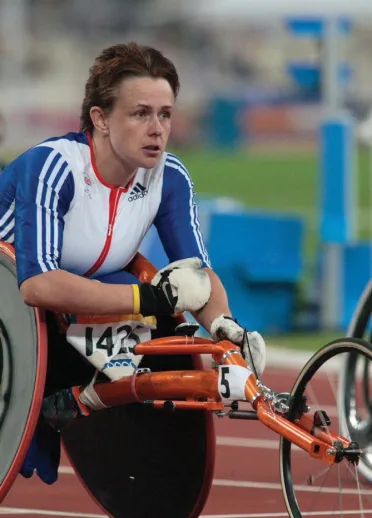 Dressed in the GB Athletic outfit, Tanni stares ahead of her with a fist wrapped and clutched in front of her