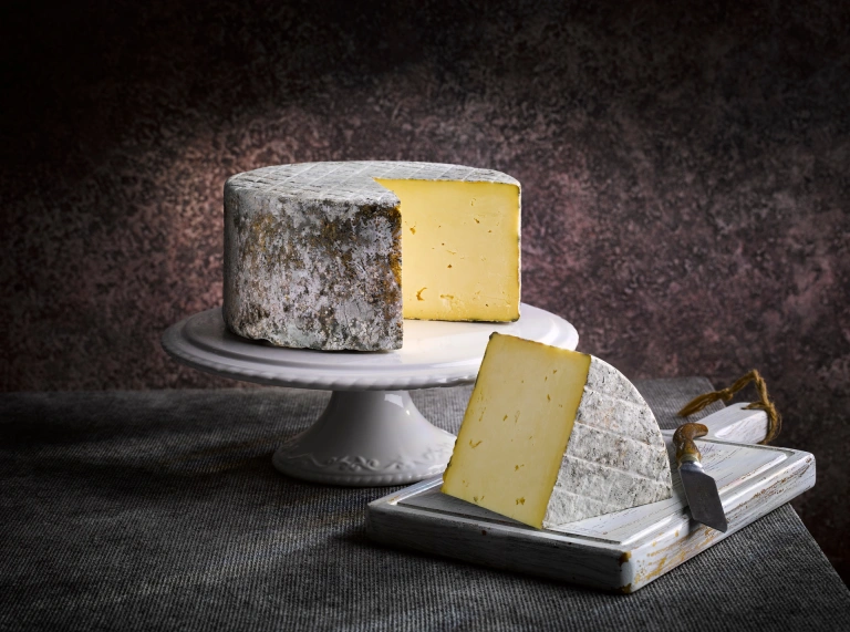 Ein runder Käse auf einem Brett.