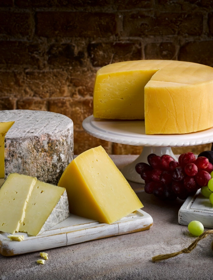 Welsh cheeses with grapes, pears and figs surrounding them.