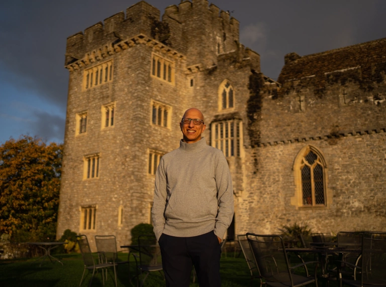 A man standing outside in front of the college.