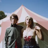 Two people standing in front of a tent.