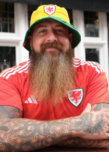 A person smiling at the camera wearing a bucket hat.