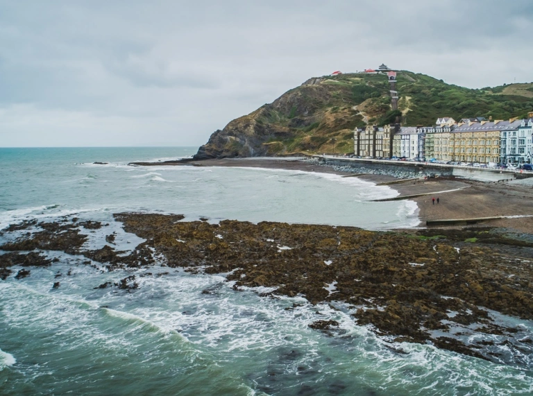 A seaside coastal area with old Victorian buildings running along the seafront