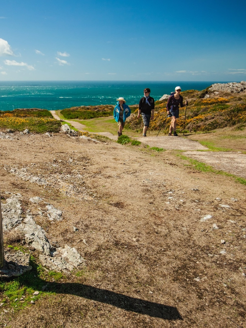 Walkers on the Wales Coast Path with the sea in the background.