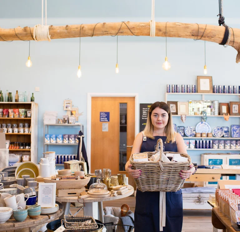 Employee holding hamper in Halen Mon gift shop
