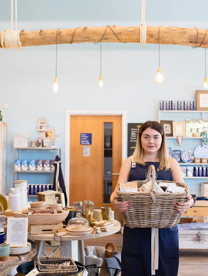 Employee holding hamper in Halen Mon gift shop