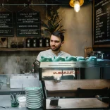 Making coffee for customer behind counter