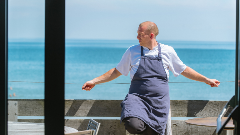 Chef Hywel Griffith at the restaurant Beach House with the sea in the background.