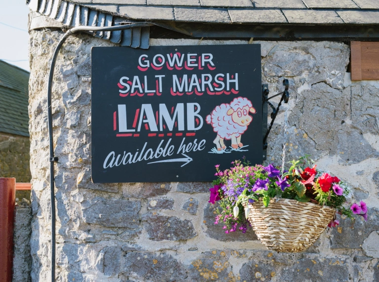 A slate sign on a stone wall.