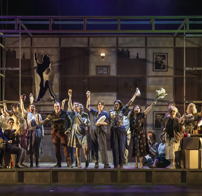 The cast of a large opera production performing on stage