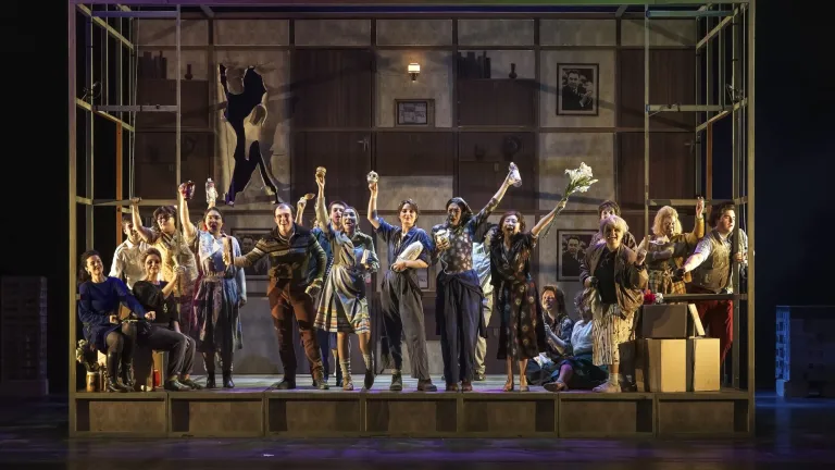 The cast of a large opera production performing on stage