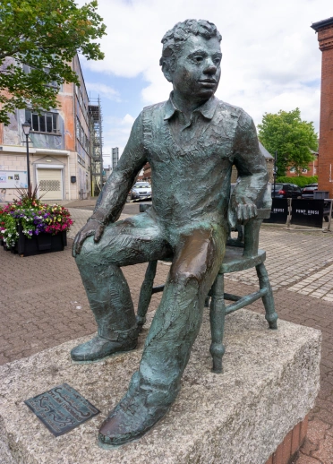 A stone statue of Dylan Thomas