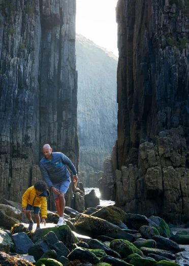 Father and son exploring  together on a rocky beach