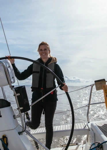 Hannah Mills steering her yacht. 